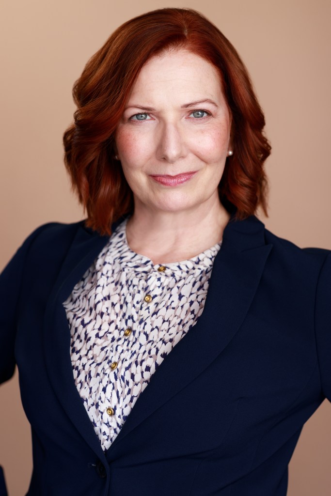 Red haired woman with floral blouse and business suit coat